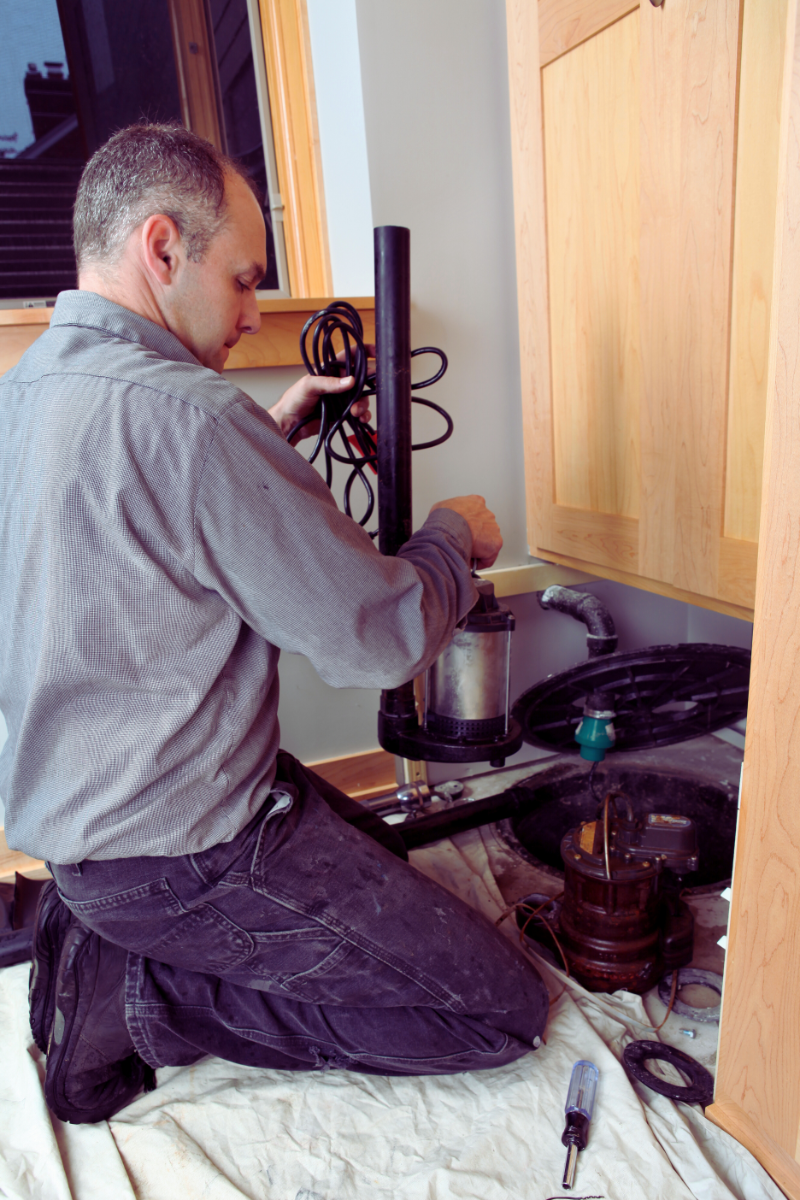 Plumber installing new sump pump