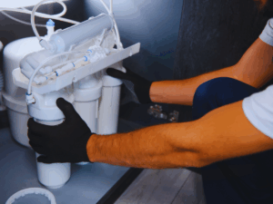 Plumber installing reverse osmosis filter