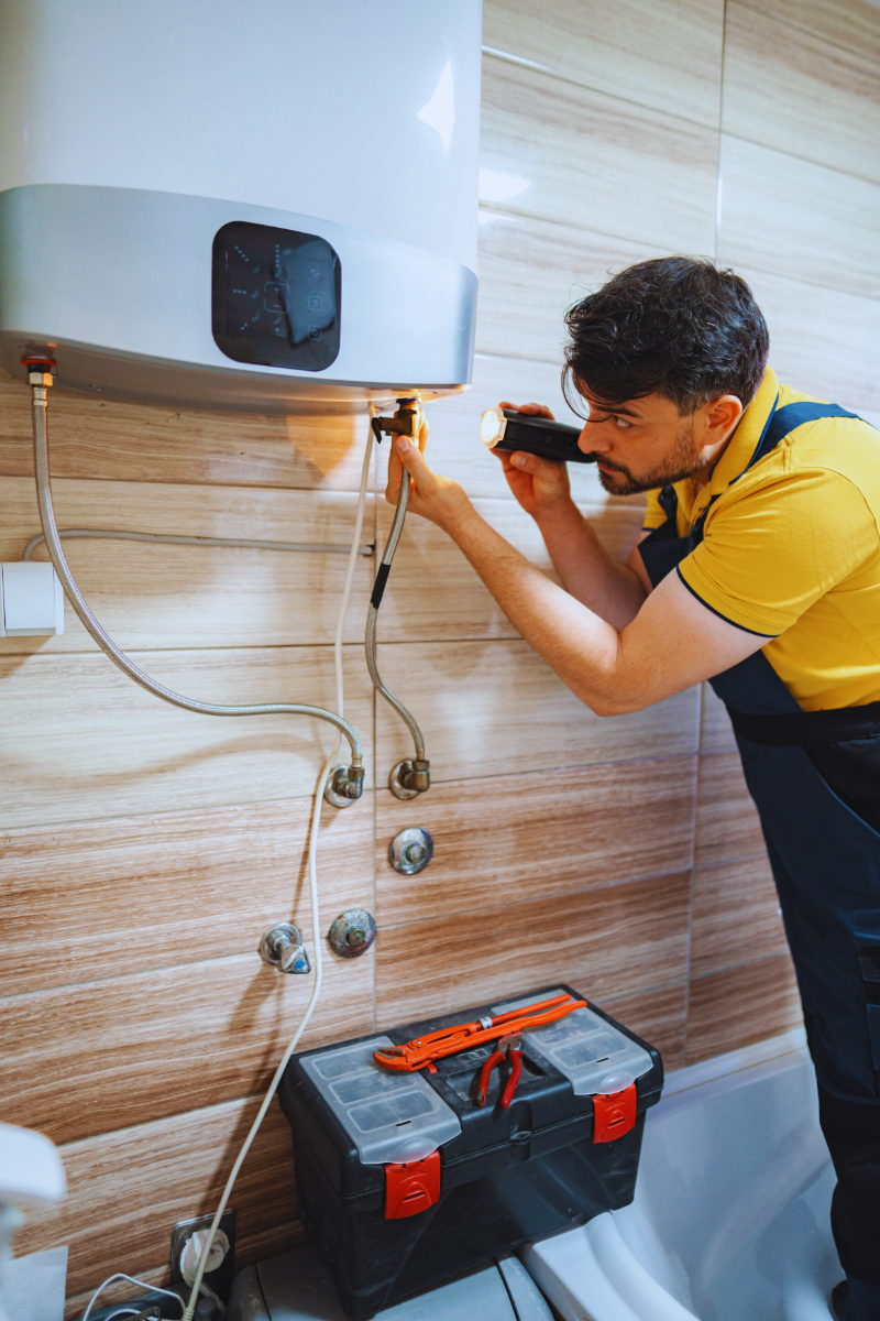 Plumber putting finishing touching on converting tank water heater to tankless